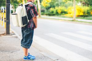 student waiting for school bus