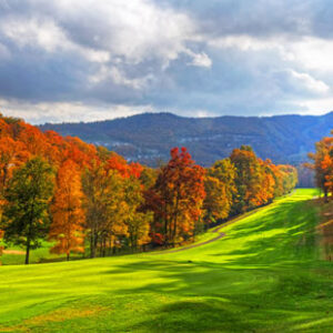 The golf course at Massanutten Resort is shown with mountains and autumn trees in the distance.