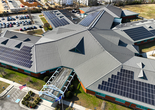 Solar panels are seen on multiple parts of the roof on a Richmond City Schools campus.