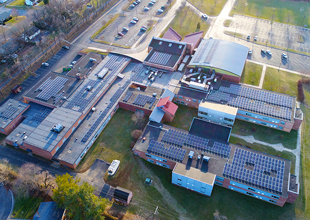 A wide aerial view of one of Waynesboro, Virginia's public school buildings. Solar panels dot the rooftops.