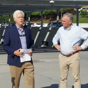 Secure Solar Futures President Anthony Smith speaks with Senator Tim Kaine at a parking facility with solar panels in Lexington, Virginia.