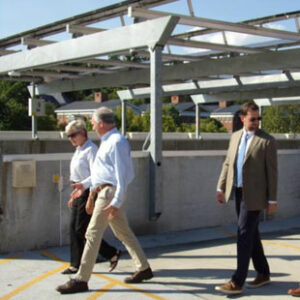 U.S. Secretary of Energy Jennifer Granholm walks with Senator Tim Kaine and Secure Solar Futures CEO Ryan McAllister at a parking lot solar array in Lexington, Virginia.