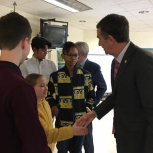 Former Virginia governor Ralph Northam shakes hands with a female student at Fisher Elementary School in Richmond, Virginia.