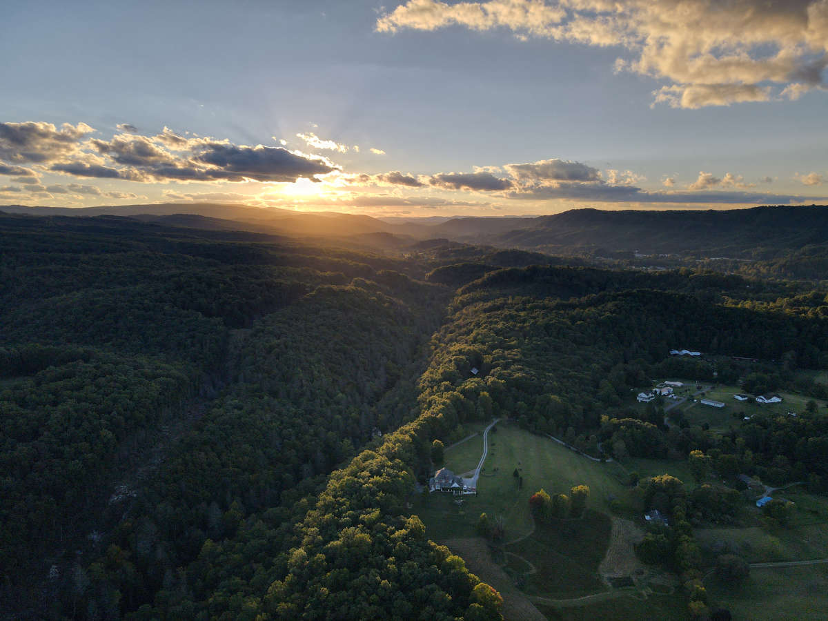 Scenic aerial photograph of the sun setting over the mountains.