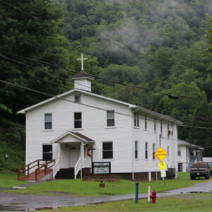 A small white church is shown surrounded by trees in a rural southwest Virginia town.