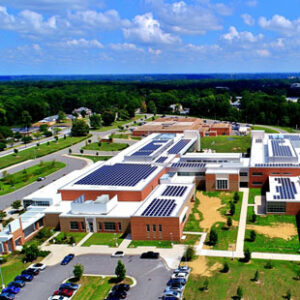 An aerial photo shows the building complex at Huguenot High School in Richmond, Virginia. Solar panels are installed on most areas of the roof.